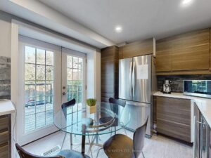 Dining area with patio doors overlooking the backyard and adjoining modern kitchen.