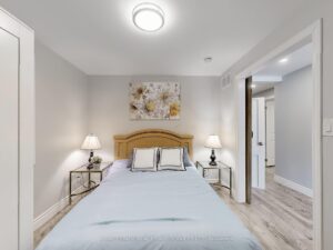 Spacious bedroom with modern flooring, neutral décor, and ample closet space.