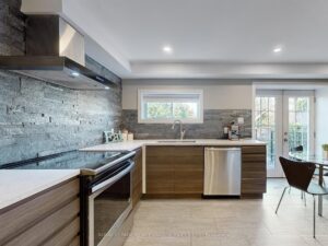 Contemporary kitchen with stainless steel appliances, tile backsplash, and walkout to the deck.