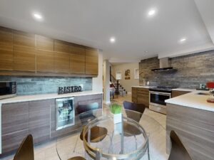 Open-concept kitchen with peninsula seating, modern cabinetry, and stainless steel appliances.