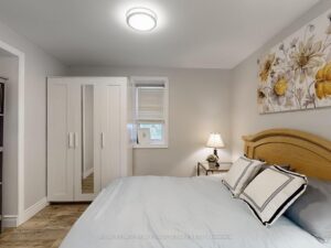 Bright bedroom with large closet, modern flooring, and neutral décor.