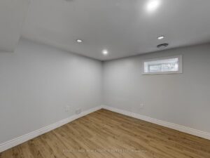 Finished lower-level recreation room with recessed lighting and durable flooring.