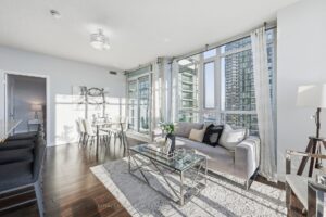 Spacious living room with floor-to-ceiling windows and panoramic city views.