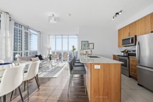 Kitchen with centre island, stainless steel appliances, and spacious dining area.