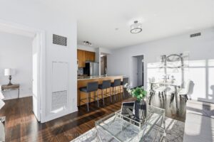 Open-concept living area with breakfast bar and floor-to-ceiling windows.