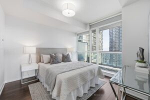 Primary bedroom with floor-to-ceiling windows and beautiful skyline views.