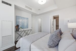 Primary bedroom with modern furnishings and walk-through access to the ensuite.