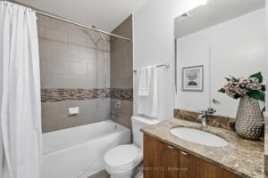 Four-piece ensuite bathroom with granite vanity and tiled bathtub surround.