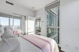 Secondary bedroom with expansive windows overlooking the city skyline.
