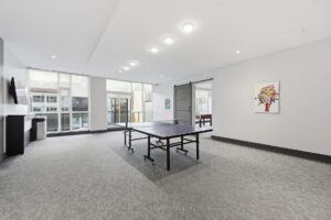 Resident recreation room with table tennis, lounge seating, and open activity space.