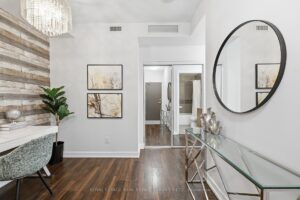 Welcoming front foyer with mirrored console table and decorative feature wall.