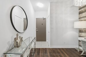 Bright front foyer with decorative mirror, console table, and entry door.