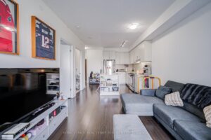 Spacious living room with media wall and open-concept layout leading to the kitchen.