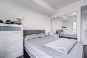 Bright bedroom with mirrored closet doors and contemporary décor.