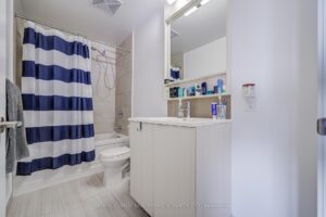 Modern four-piece bathroom with vanity, bathtub, and shower curtain.