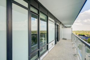 Private covered balcony with glass railings and panoramic neighbourhood views.
