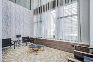 Resident lounge with floor-to-ceiling windows and contemporary seating.