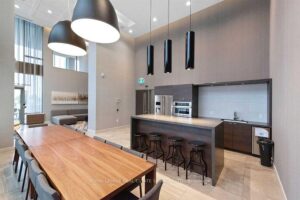 Stylish party room with dining table, lounge seating, and modern kitchen.