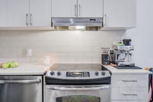 Contemporary kitchen with stainless steel range, subway tile backsplash, and quartz countertops.