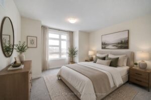 Spacious primary bedroom with large window, plush carpeting, and neutral contemporary décor.