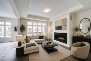 Open-concept family room featuring a modern linear fireplace and large picture windows.