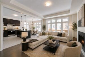 Open-concept family room featuring a modern linear fireplace and large picture windows.