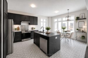 Bright modern kitchen with quartz island, stainless steel appliances, and stylish backsplash.