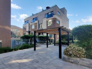 Landscaped courtyard with covered pergola seating at a modern condominium community in Oakville.