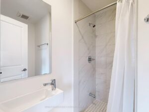 Modern 4-piece bathroom with marble-look tiled shower, vanity, and contemporary fixtures.