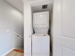 Convenient in-suite laundry closet with stacked washer and dryer.