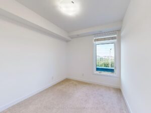 Bright secondary bedroom with plush carpeting, large window, and neutral finishes.