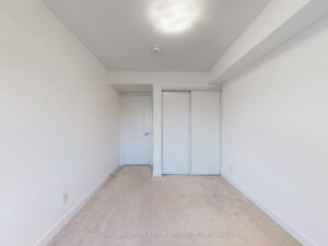 Spacious bedroom with double closet, soft carpeting, and recessed ceiling detail.
