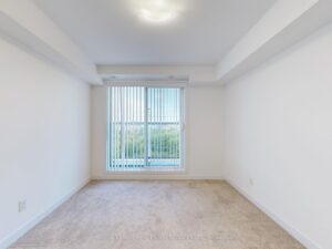 Sun-filled bedroom featuring a large window, plush carpeting, and contemporary design.