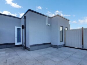 Private rooftop terrace with durable stone pavers and modern privacy fencing.