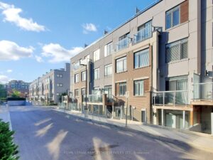 Exterior view of contemporary condo townhomes with private balconies and landscaped streetscape.