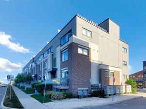 Exterior view of a modern corner townhouse with contemporary architecture and landscaped grounds.