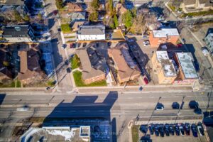 Top-down drone view showing the two apartment buildings, parking areas, and surrounding neighborhood.