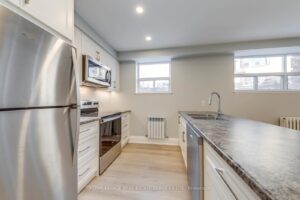 Modern kitchen featuring stainless steel appliances, white cabinetry and spacious peninsula with seating.