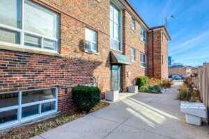 Exterior view of the low-rise residential building with landscaped walkway and secure entrance.