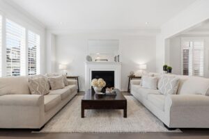 Bright living room with gas fireplace, plantation shutters, and abundant natural light.