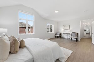 Open-concept primary bedroom with sitting area and view toward the ensuite and hallway.