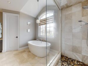 Luxury ensuite bathroom with glass walk-in shower, freestanding tub, and contemporary finishes.