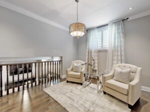 Open loft sitting area overlooking the foyer with hardwood flooring and elegant lighting.