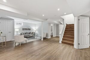 Finished basement with recreation space, modern flooring, and staircase access.