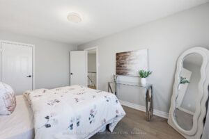 Bedroom with large window, neutral décor, and contemporary furnishings.