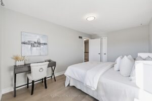 Bedroom or office with desk area, modern flooring, and neutral décor.