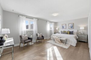 Large primary bedroom with sitting area, abundant natural light, and modern décor.