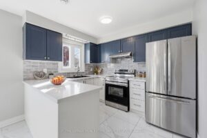 Bright kitchen with centre island, stainless steel appliances, and ample cabinetry.