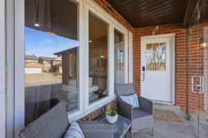 Covered front porch with decorative wood ceiling and double-door entry.