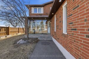 Side yard view with fencing, lawn area, and rear deck access.